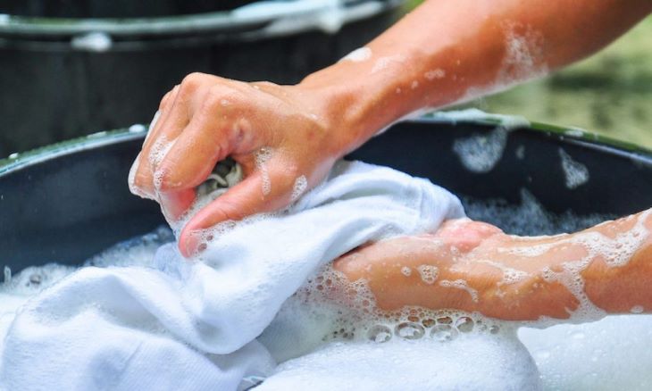 Nên giặt tay riêng đối với quần áo dính xăng, dầu